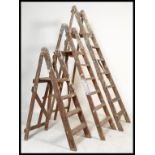 A group of three vintage 20th Century Industrial wooden step ladders, the three step ladders in