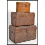 A group of vintage early 20th century tin trunks and luggage to include hat box, a medium trunk