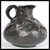 A 19th century Art Nouveau bronze ewer jug having a bulbous body with shaped hoop handle with sea