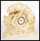 An early 20th century chalk ware mantel clock in the form of a tiger fighting a snake with central