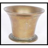 A brass 18th century trumpet shaped mortar with a circular foot base and engraved rim.