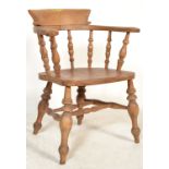 A Victorian beech wood and elm smokers bow armchair with spindle back above solid elm seat on