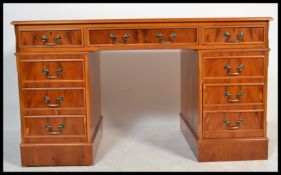 A good 20th Century contemporary yew wood twin pedestal desk, an arrangement of nine drawers,
