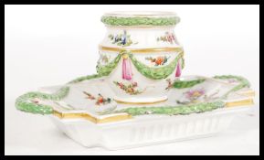 A 19th century Dresden inkwell set onto a rectangular base having ornate hand painted  garland
