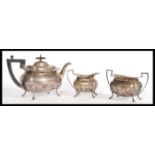 A vintage early 20th century Walker and Hall silver tea set with pad feet and shell form shoulders