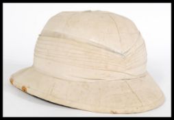 A 20th century foreign service military khaki pith helmet with a leather sweat brand and green cloth