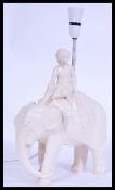 A vintage 20th century retro chalk ware lamp in the form of an elephant and rider, please see