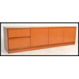 A retro 20th Century teak wood Danish inspired low sideboard having an arrangement of cupboard and