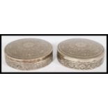 A pair of Persian Iranian silver white metal trinket boxes of circular form with Islamic geometric