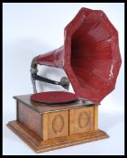 A vintage 20th century gramophone record player having an oak case with large red painted morning