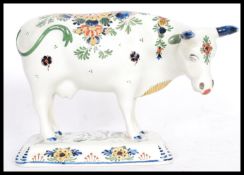 A 19th / 20th Century Delft ceramic figurine of a cow having hand painted floral sprays with painted