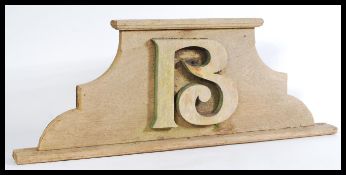 An early 20th century French wooden door pediment of ached form having a carved letter B to top.
