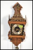 A vintage 20th century wooden wall cuckoo clock having brass drop weights. The dial having a Roman