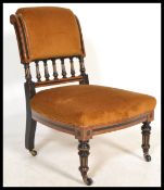 A 19th Century Aesthetic movement walnut and ebonised frame nursing chair, gallery rail to rear,