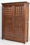 An unusual early 20th century French gothic oak double wardrobe armoire. The full length doors