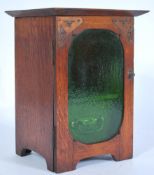 A vintage early 20th century Art Nouveau / Arts and Crafts oak smokers pipe cabinet having front