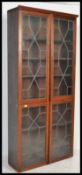 A vintage 1930's oak twin door leaded glass bookcase, adjustable shelves to the inside. Measures 206