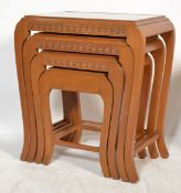 A Chinese mid century camphor wood quartetto nest of tables of shaped form with carved detailing