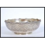 An Iranian Persian silver white metal serving bowl with an embossed floral Islamic design, shaped