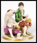A 20th century continental porcelain figure group depicting two urchins eating fruit by Rudolph