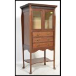 An early 20th century Edwardian mahogany music cabinet with fold front drawers with brass swing