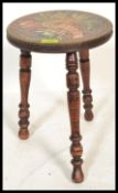 An early 20th Century Arts and Crafts inspired milking stool, raised on turned tripod supports,the