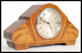 A 20th century Art Deco style walnut mantel clock with triptych paneling with a Swiss made clock