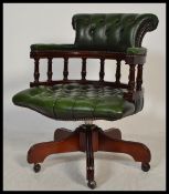 A 20th century green Leather Chesterfield Captains deep button back mahogany framed swivel