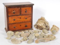 A 19th century miniature wooden apprentice piece chest of drawers with a collection of fossils