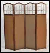 An Edwardian mahogany and glass ladies four fold discretion panel screen having arched glass
