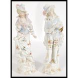 A pair of 19th century continental German figurines numbered 6 and 32, depicting a gentleman and