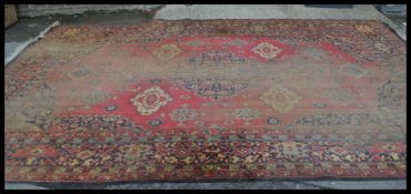 A 20th century Persian rug with red ground and central medallion having decorative spandrels to