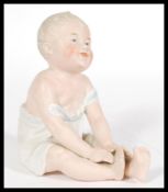 A 19th Century Continental bisque ceramic Piano Baby figurine, stamped 28 to the base, please see