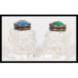 A pair of early 20th century small cut glass jars on square bases with stamped sterling silver 925