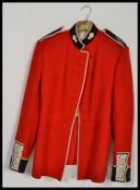 A vintage 20th century grenadier Guardsman's dress jacket, with cobalt collar and cuffs with coat of