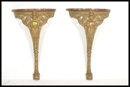 A pair of late 19th Century / early 20th Century gilt cast metal hall tables, each cast with the