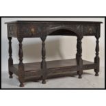 A Jacobean 19th century revival hall  console lowboy table, heavily carved throughout, arched frieze