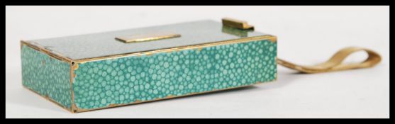 A vintage mid 20th century compact with made of brass with a green shagreen effect to the exterior