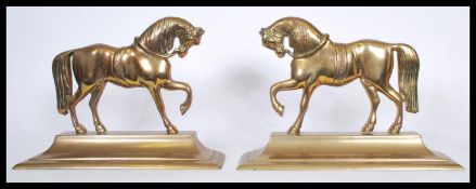 A pair of 19th century brass andiron firedog fireside ornaments in the form of horses being raised