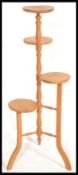 A 20th Century four tier pine plant stand / torchere, central turned column raised on tripod splayed