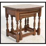 A 20th Century Old Charm oak nest of tables, each table raised on turned supports united by