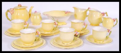 A Royal Winton art deco tea service having yellow decoration with floral handles. Stamped to