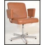 A vintage / retro 20th Century swivel chair - desk armchair being raised on a chrome adjustable