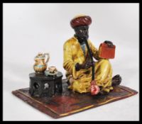 A 20th century Austrian cold painted bronze figure of an Arab smoking a pipe on a rug in the