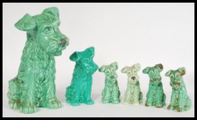 A collection of vintage 20th century SylvaC ornaments of graduating green terrier dogs, numbers