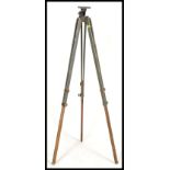 A vintage retro 20th century Military tripod having folding adjustable legs with brass mounts.