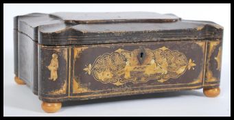 A 19th century lacquer sewing box with chinoiserie style decoration of cartouche form having gilt
