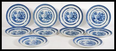 A set of 10 early 19th century blue and white plates with geometric detailing to the rim and a scene