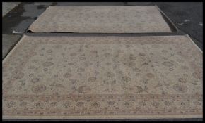A pair of very large contemporary floor carpet rugs having beige ground with scrolled floral
