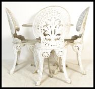 A cream painted cast metal five piece garden / terrace set comprising table of circular form with